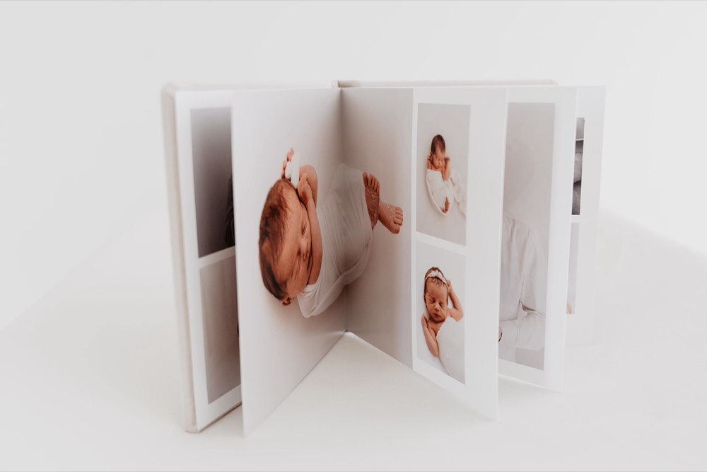 Aufgeschlagenes FineArt-Fotoalbum mit Neugeborenenfotos